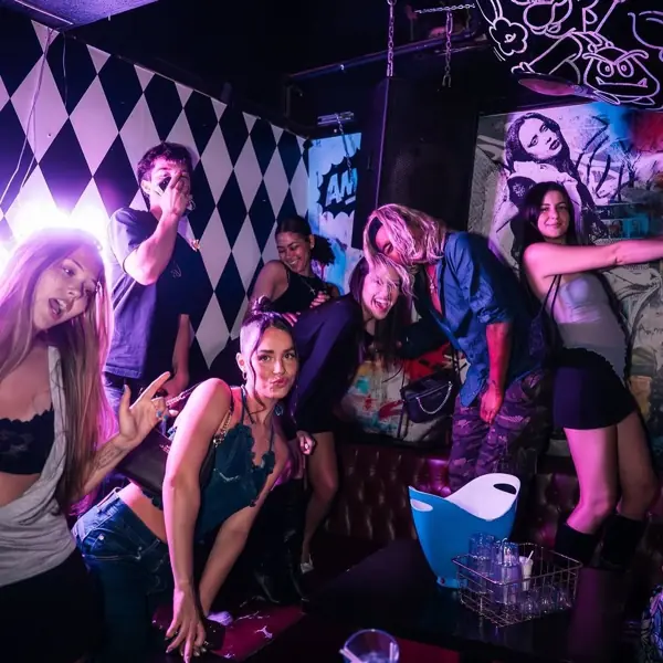 Partygoers against the black-and-white checkered neon wall