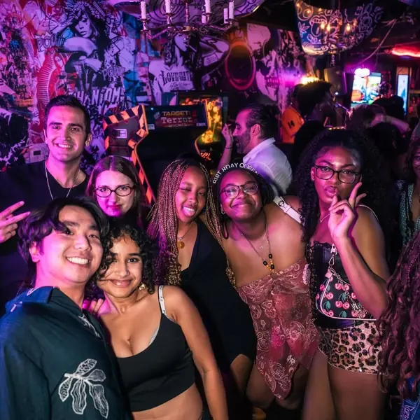A packed crowd under purple and pink neon lights