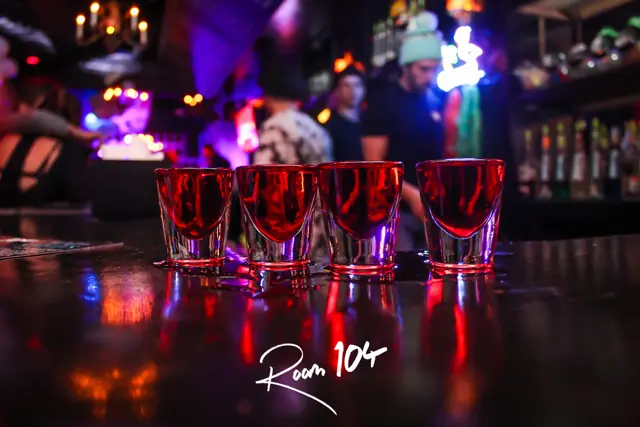A row of red shots lined up on the bar